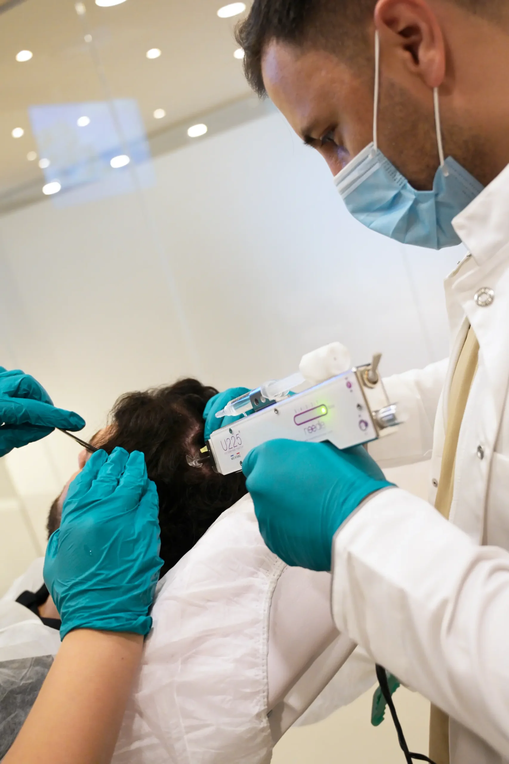 Close-up van specialisten die een stamcelondersteunende haartransplantatie behandeling uitvoeren bij een patiënt bij Armeda Clinics in Eindhoven