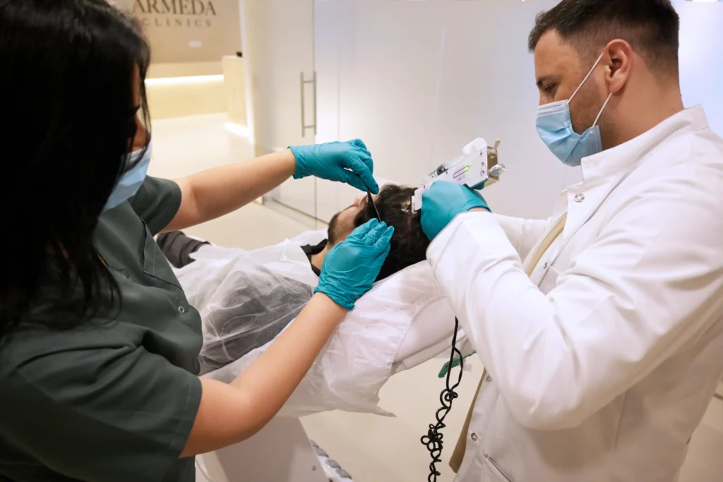 Specialisten voeren een stamcelondersteunende haartransplantatie behandeling uit bij een patiënt bij Armeda Clinics in Eindhoven