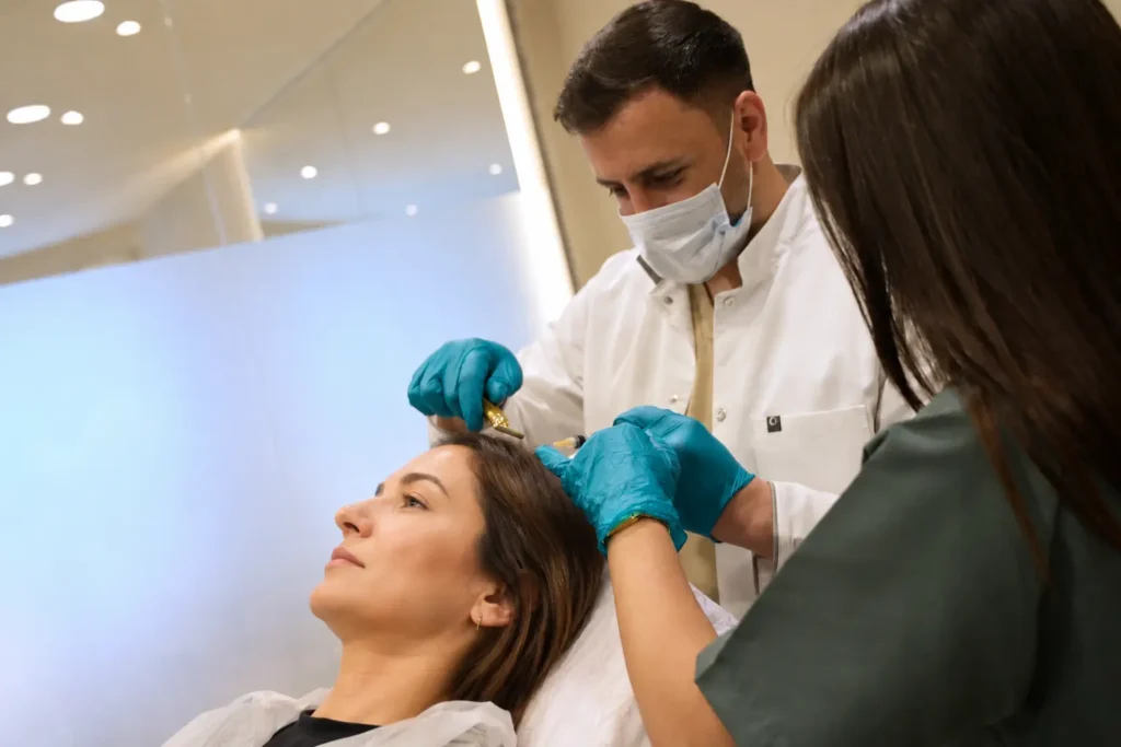 Specialist voert haartransplantatie behandeling uit bij een vrouwelijke patiënt bij Armeda Clinics in Eindhoven
